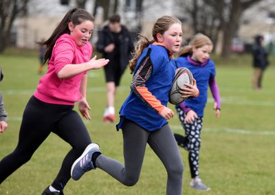 Girls running with rugby ball